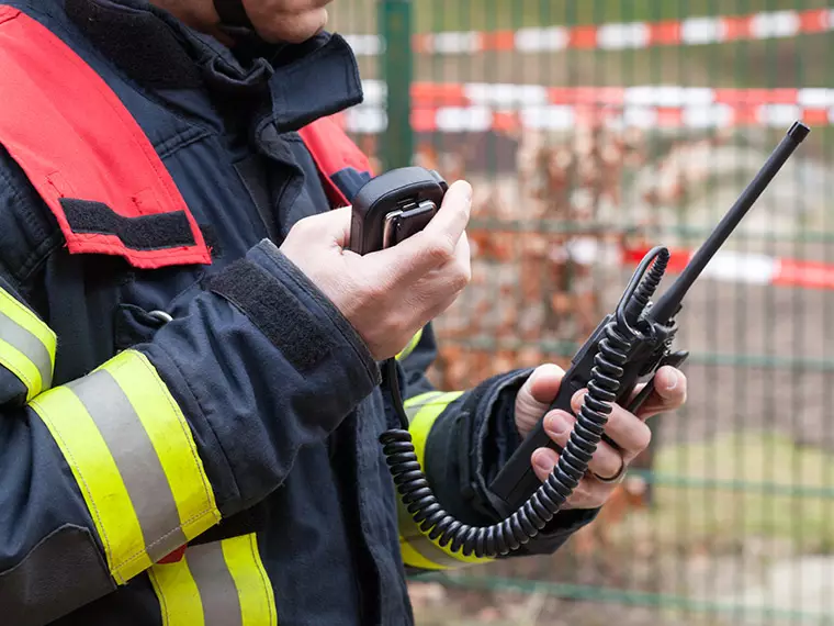 Application de la sécurité publique - Pompier en gilet rouge tenant une radio portable